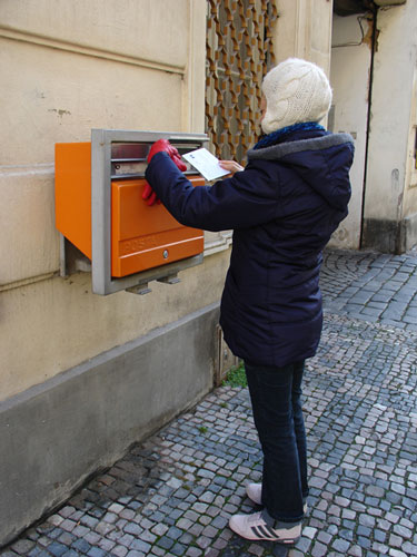 Foto de Sofía depositando postal en un buzón de Praga